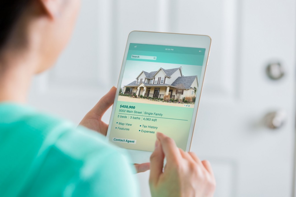 man checking property listing on tablet